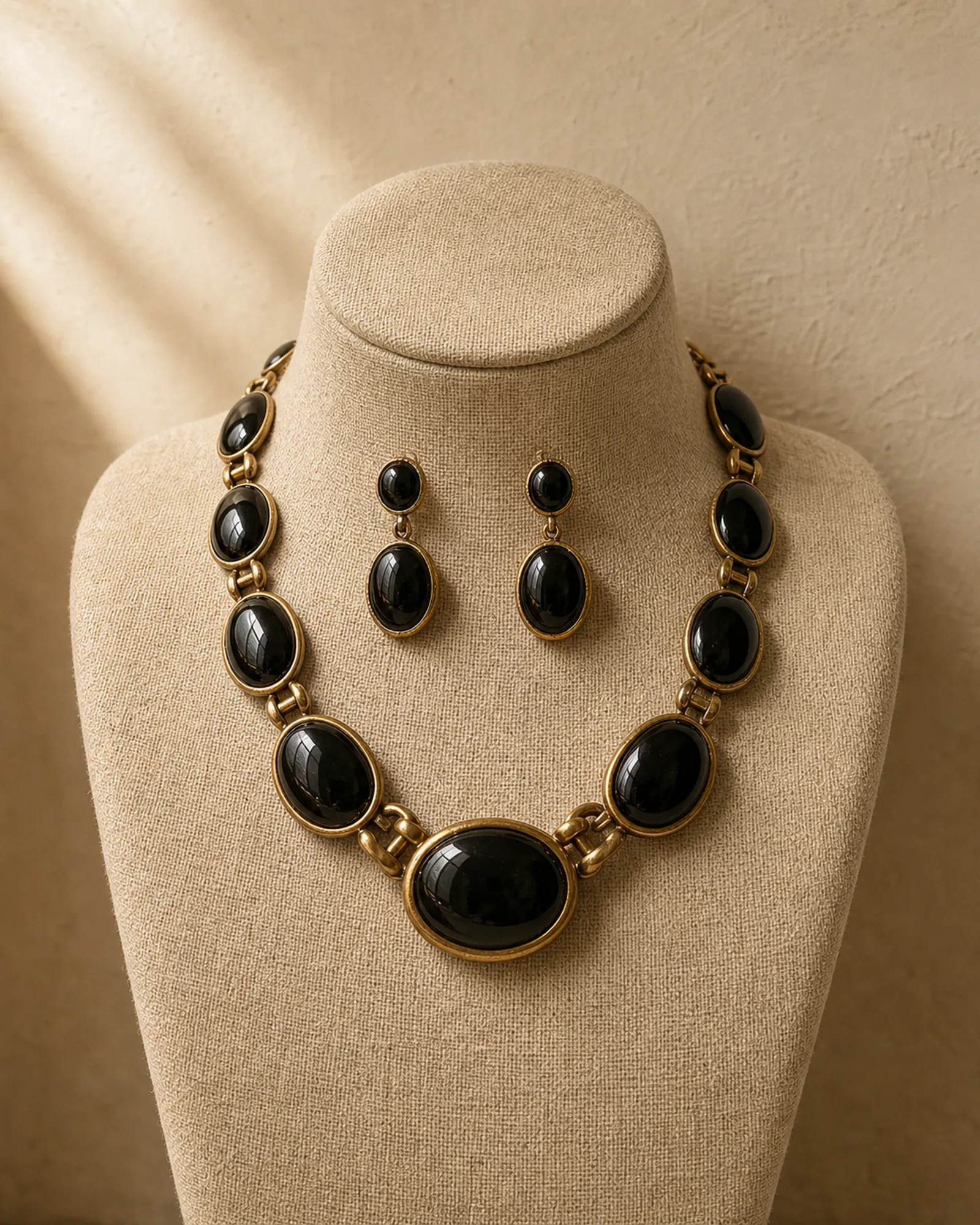 Editorial mockup of a black cabochon collar necklace and earrings